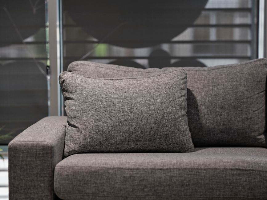 Elegant grey sofa with plush cushions in a contemporary living room setting.